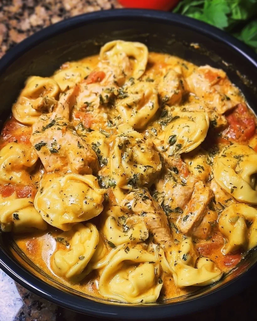 Delicious CrockPot Chicken Tortellini served in a bowl with fresh herbs