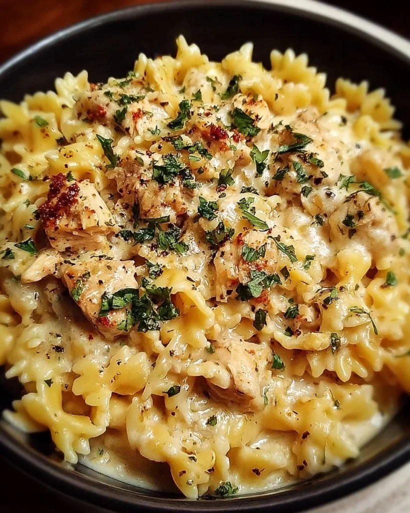 Creamy crockpot garlic parmesan chicken pasta garnished with herbs