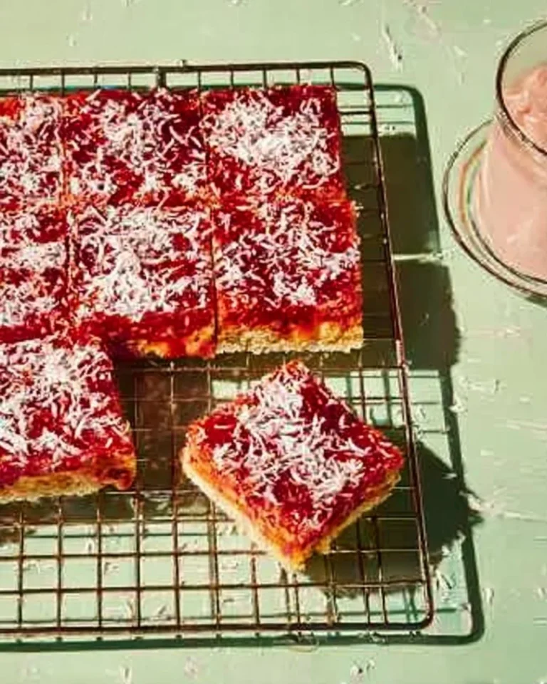 Delicious Coconut Raspberry Traybake topped with creamy pink custard