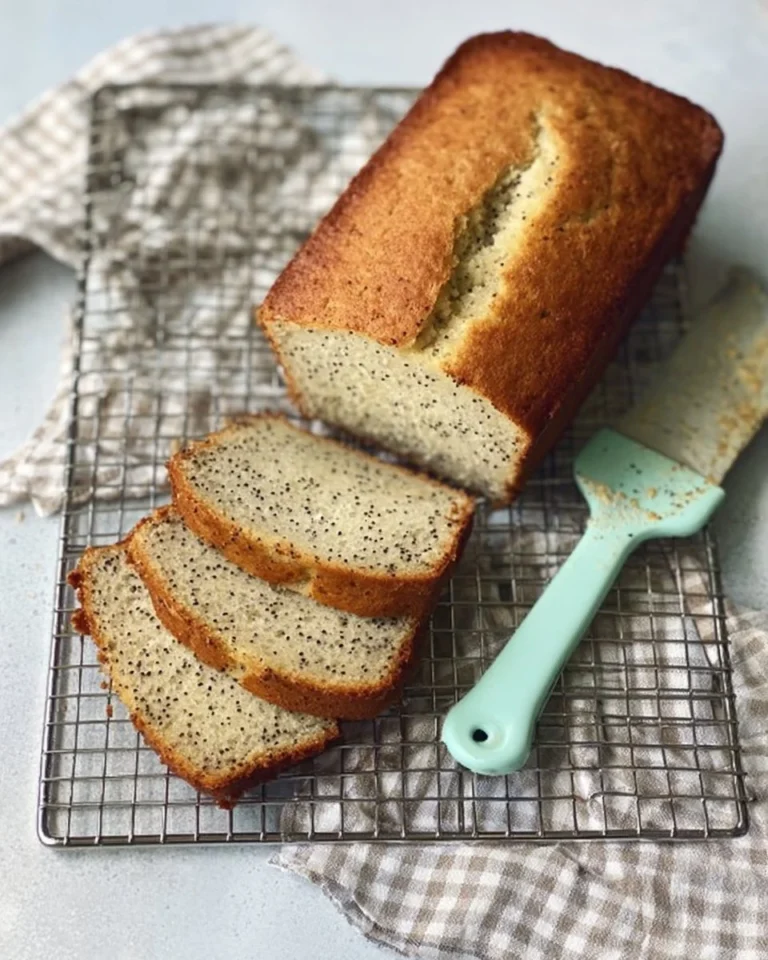 Loaf of freshly baked almond poppy seed bread with poppy seeds on top