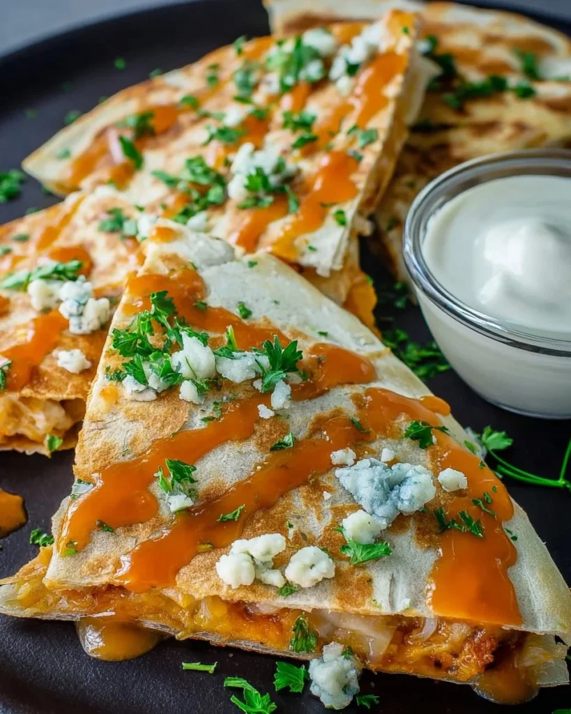 Plate of spicy Buffalo Chicken Quesadillas with melted cheese and herbs.