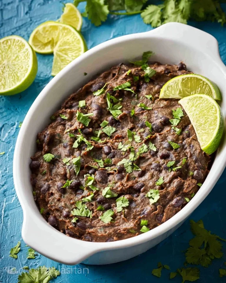 Bowl of easy refried black beans with spices and green onions